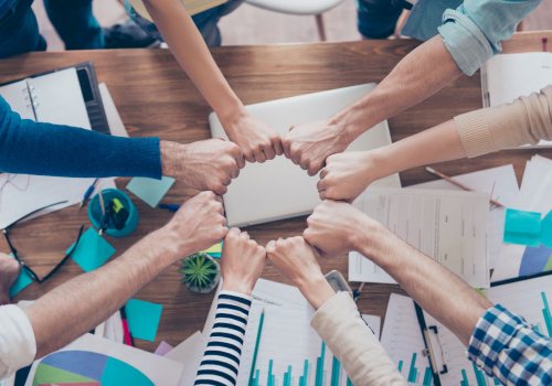 Medewerkers vormen team met vuisten tegen elkaar